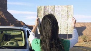 935652-woman-reading-map-by-car